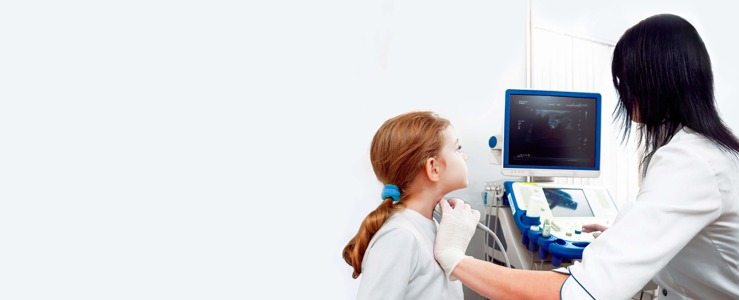 Female doctor performing ultrasound a little girl